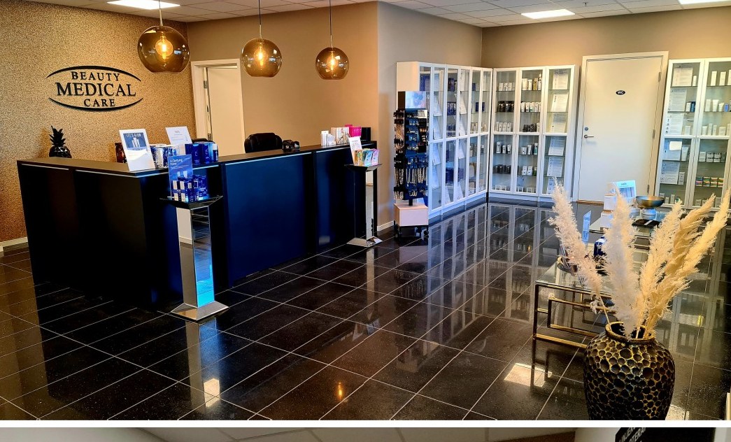 Resepsjonen hos Beauty Medical Care med gullvegg og produkthyller